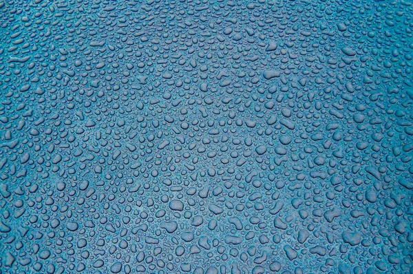 Su damlaları turkuaz camlara düşer.