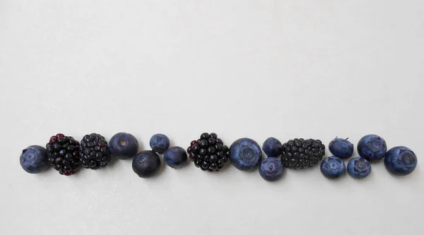 Beyaz arka planda taze böğürtlen ve yaban mersini.