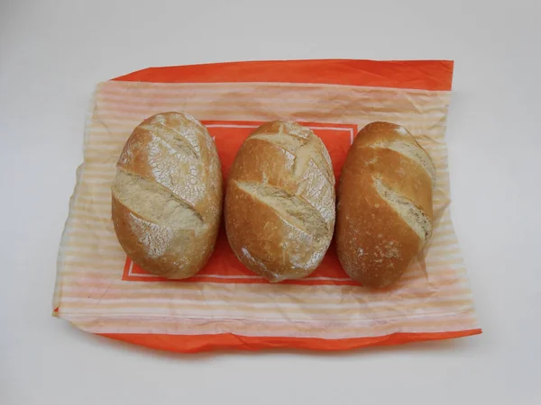 Beyaz arka planda kağıt torba içinde lezzetli ekmek.