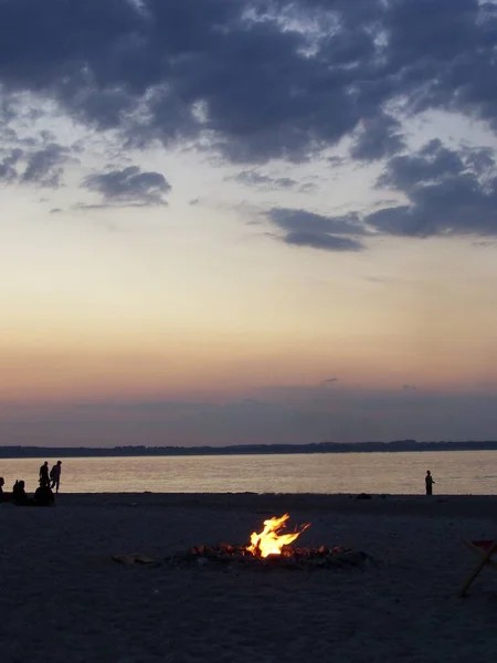 Gün batımında sahilde kamp ateşi