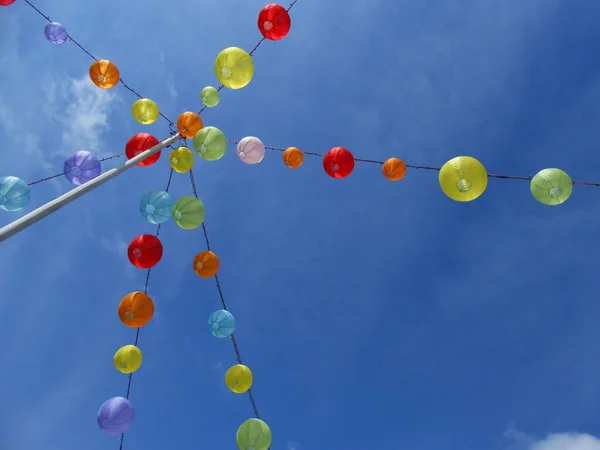 Mavi gökyüzüne karşı renkli fenerler