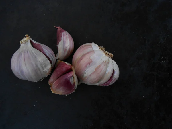 Kırmızı sarımsak, siyah arka planda, üst tarafta.