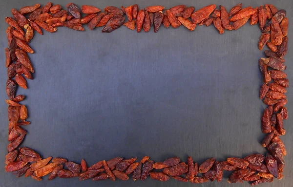 Kurutulmuş kırmızı kırmızı kırmızı biber, siyah bir arkaplanda çerçeve olarak.