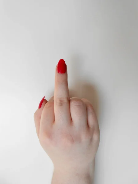 Beyaz arka planda orta parmağı olan kadın eli