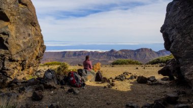 Hiking woman takes a break watching the landscape