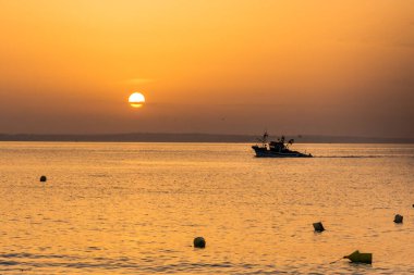 Fishermen ship at morning sun returns into the port