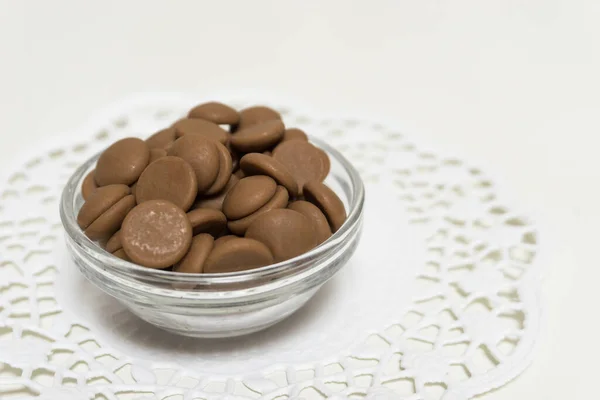 Many Brown Chocolate Pellets Glass Bowl White Background — Foto Stock