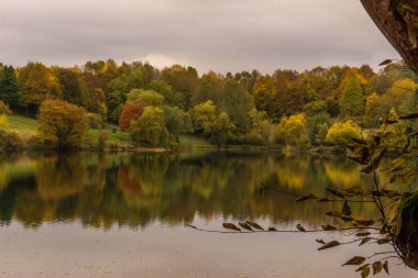 caldera lake of Ulmen with view at colorful forest in autumn, Germany