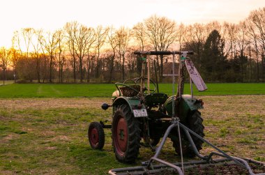 Eski traktör gün batımında çayırda