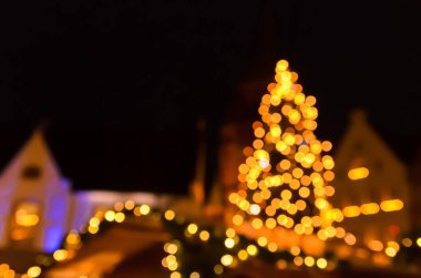 Bulanık görüntü, gece vakti Alman Noel pazarındaki bir Noel ağacının görüntüsü.