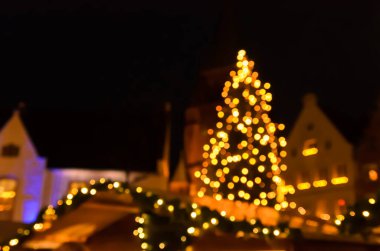 Bulanık görüntü, gece vakti Alman Noel pazarındaki bir Noel ağacının görüntüsü.
