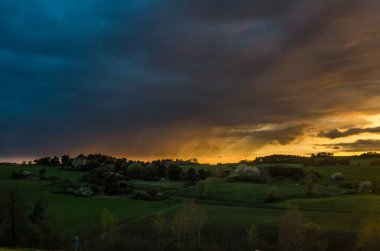 Almanya, Eifel 'de tepelik çimlerin üzerinde dramatik bulutlu bir hava hakimdi.