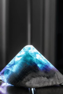 Parlayan küçük bir kristal piramit.