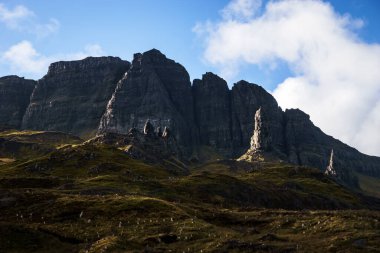 Fırtınanın İhtiyar 'ı altın ışıkta gün batımında sıra dışı ön perspektifte koyu kaya oluşumuyla İskoçya' nın Skye Adası 'nda