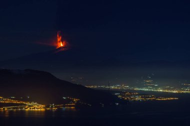 Etna volkanında gece vakti meydana gelen patlama ön planda deniz ve şehir ışıkları 10 Şubat 2022 'de İtalya' nın Sicilya kentinde görüldü.