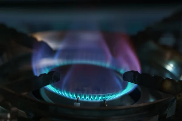 Blue flame of burning butane gas on a stove