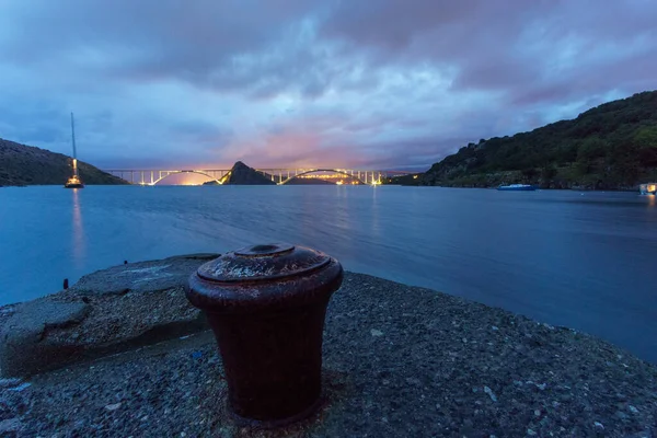 Bollard beton iskelede köprü ile deniz aşırı Krk adasına geceleri arka planda