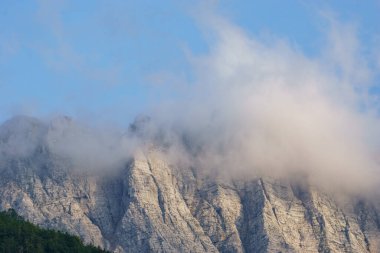 Julian Alps, Triglav Ulusal Parkı, Slovenya 'da bulutlu dağ manzarasında kaya duvarı