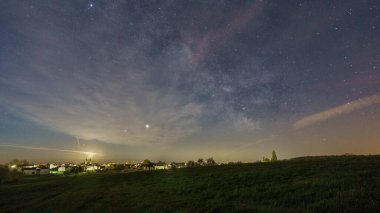 Hilal ay ve Samanyolu bulutların arkasında, Eifel 'deki bir Alman köyünün dışındaki çayır üzerinde.
