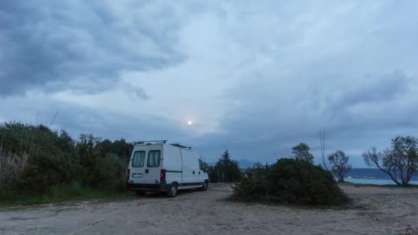 希腊伯罗奔尼撒 一辆载有升起的月亮和移动的云彩的野营面包车在黄昏时分在海滩上的时间流逝 — 图库视频影像