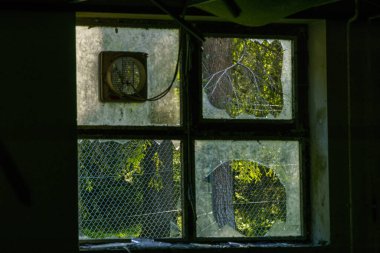 Boş bir sanayi binasının dışındaki kırık pencerenin ayrıntıları