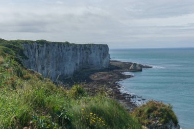 High angle view at teh coastline with chalk cliffs, rock formations and green hills on a summer day at Etretat, Normandy, France