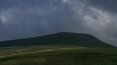 Gün batımında, Brecon Beacons Ulusal Parkı, Galler 'deki Fan Gyhirych dağının üzerinden geçen altın saat boyunca hareket eden bulutların hızlanması