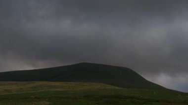 Gün batımında, Brecon Beacons Ulusal Parkı, Galler 'deki Fan Gyhirych dağının üzerinden geçen altın saat boyunca hareket eden bulutların hızlanması