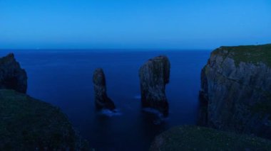 Elegug Stacks iğnesinin Pembrokeshire Coast Ulusal Parkı, Galler 'de geceden gün doğumuna kadar sürmesi