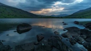 Snowdonia Ulusal Parkı 'ndaki Llynnau Mymbyr Gölü' nde gün batımının hızlanması Birleşik Krallık 'ın uzak dağları Snowdon' da görülebilir.