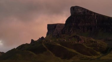 Gün batımında Quiraing 'in bir kaya oluşumu önünde hareket eden bulutların zaman aşımı, İskoçya' nın Skye Adası, Birleşik Krallık