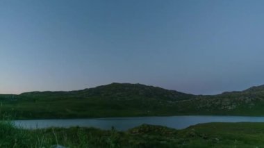 Highlands, Lairg, İskoçya, Birleşik Krallık 'taki Kuzey Sahili 500' de bulunan Gainmhich Gölü üzerinde altın gün batımından gündoğumuna kadar zaman geçti.