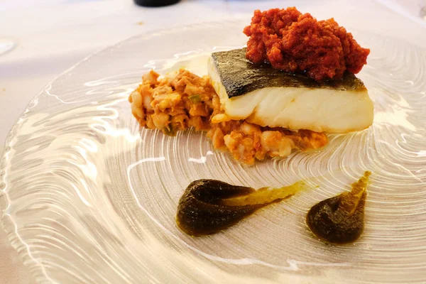 Piece of cod with skin and vegetable garnish