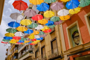 Sokak renkli şemsiyelerle kaplı.