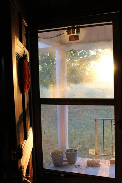 Fall sunshine streaming in through front door decorated for Halloween.