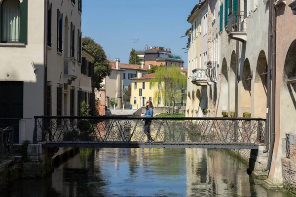 İtalya 'da bir kanalda eski bir metal köprüde bir kadın. Treviso.