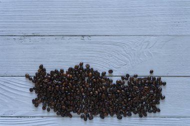 Coffee beans isolated on white wooden background