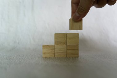 İş ve tasarım konsepti için Üçgen şeklinde istiflenmiş el yapımı ahşap zarlar, liderlik sembolü, takım çalışması ve büyüme.