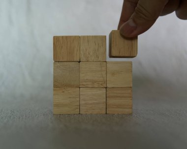 Yakın çekim el, iş ve tasarım konsepti, liderlik sembolü, takım çalışması ve büyüme için kare şeklinde tahta bir zar seçin