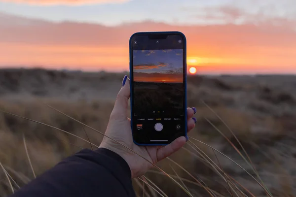 early in the morning to watch the dawn in the dunes, pink dawn, the play of light, the world wakes up, take a photo by phone