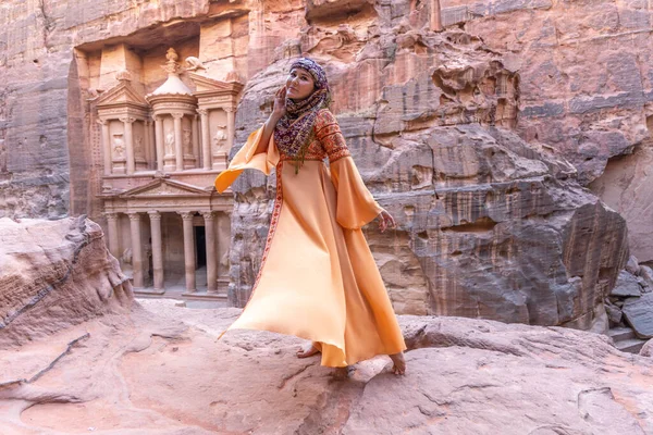 佩特拉宫是身穿传统服装 头戴头巾 站在岩石顶上的女人的背景 — 图库照片