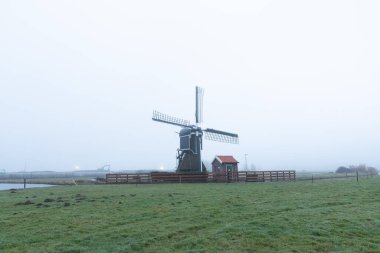 Sabah erken saatlerde yel değirmeninin görüntüsü Yağmurdan sonra sisli hava