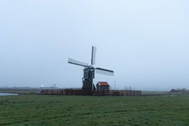 Sabah erken saatlerde yel değirmeninin görüntüsü Yağmurdan sonra sisli hava