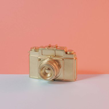 Çift renkli pastel arka planda Altın Retro fotoğraf makinesi. 70 'lerin hafif ve metalik kare kompozisyonu geçmiş.