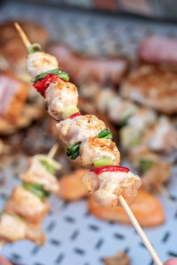 Tavuk göğsü ve domuz eti taze renkli ve lezzetli sebzelerle ahşap şişte çekiliyor.