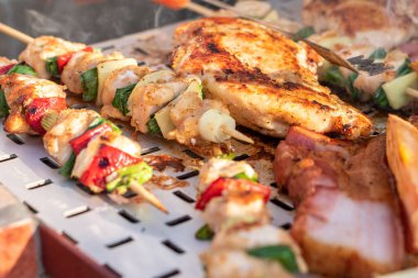 Tavuk göğsü ve domuz eti taze renkli ve lezzetli sebzelerle ahşap şişte çekiliyor.