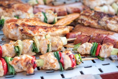 Tavuk göğsü ve domuz eti taze renkli ve lezzetli sebzelerle ahşap şişte çekiliyor.