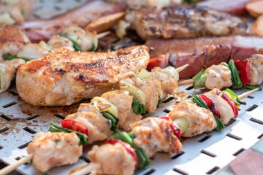 Tavuk göğsü ve domuz eti taze renkli ve lezzetli sebzelerle ahşap şişte çekiliyor.
