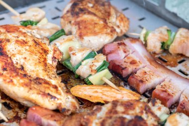 Tavuk göğsü ve domuz eti taze renkli ve lezzetli sebzelerle ahşap şişte çekiliyor.