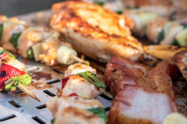 Tavuk göğsü ve domuz eti taze renkli ve lezzetli sebzelerle ahşap şişte çekiliyor.
